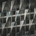 A striking modern building facade showcasing glass panels and geometric patterns, offering a sleek architectural style.
